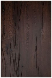 Dunkle Holz-Tischplatte mit markanter Maserung, aus der Vogelperspektive fotografiert.