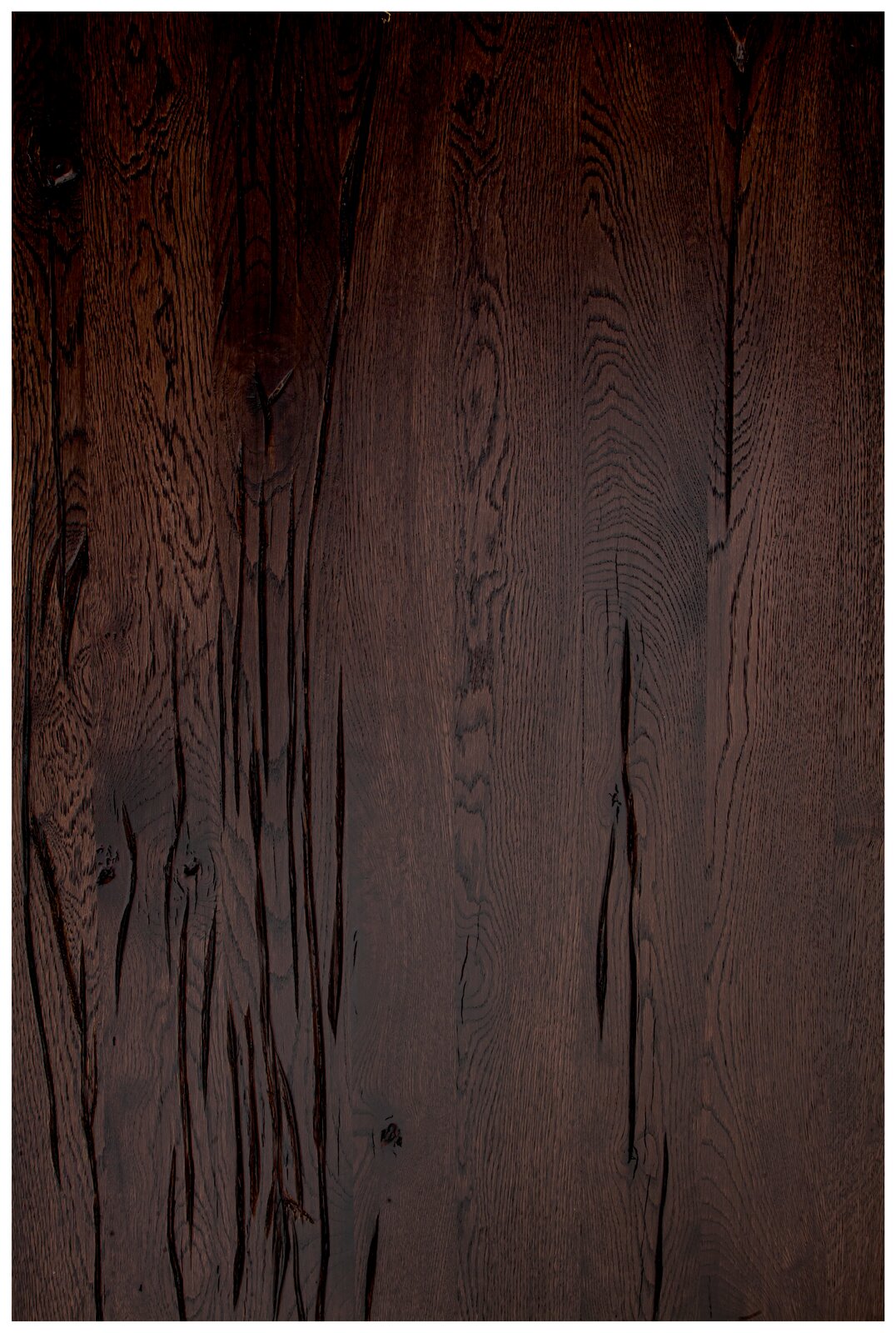 Dunkle Holz-Tischplatte mit markanter Maserung, aus der Vogelperspektive fotografiert.