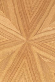 Nahaufnahme einer Tischplatte mit einem geometrischen Holzfurniermuster in warmen Brauntönen, von oben betrachtet.