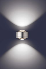 Moderne LED Wandleuchte in silberner Optik, die von oben betrachtet wird und ein elegantes Lichtmuster an die Wand projiziert.