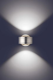 Moderne LED Wandleuchte in silberner Optik, die von oben betrachtet wird und ein elegantes Lichtmuster an die Wand projiziert.