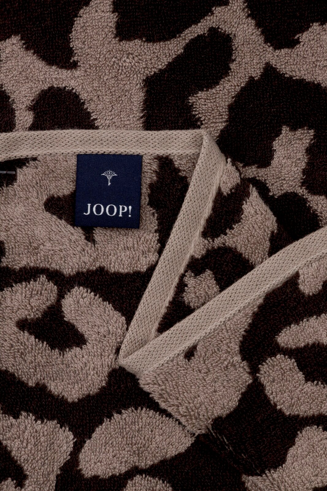 Close-up van een JOOP!-saunadoek met luipaardprint in bruin- en beigetinten, met zichtbaar label.