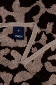 Close-up van een JOOP!-saunadoek met luipaardprint in bruin- en beigetinten, met zichtbaar label.