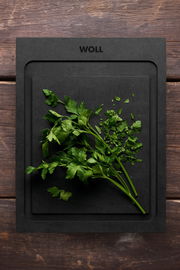 Schneidebrett S 25x19cm von oben mit frischer Petersilie darauf, auf einer Holzoberfläche.