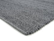 Grauer Handwebteppich in Nahaufnahme, perspektivisch von der Seite fotografiert.