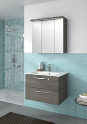 Moderner Badblock mit Spiegelschrank und Waschbecken aus der Perspektive von vorne, umgeben von blauen Fliesen.