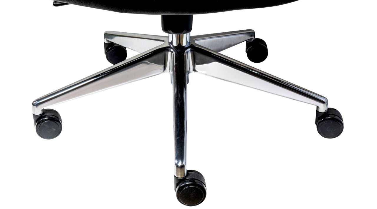 Nahaufnahme der Basis eines Chefsessels mit fünf Rollen und verchromtem Gestell, von unten fotografiert.