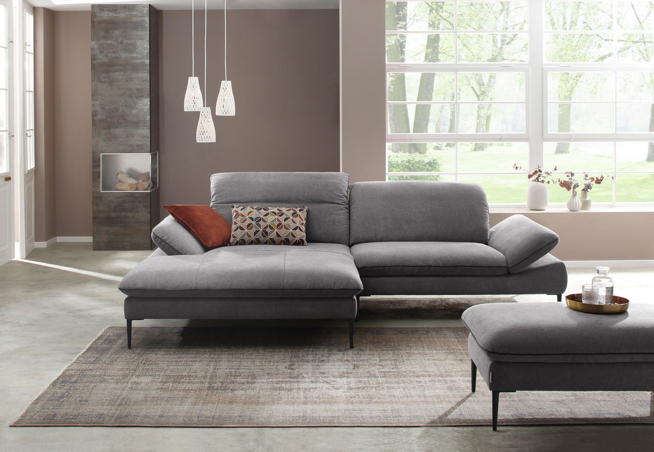 Großer grauer Hocker in einem modernen Wohnzimmer, seitliche Perspektive