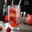 Doppelwandiges Glas mit Himbeer-Cocktail, Strohhalm und Eiswürfeln, seitliche Perspektive