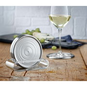 Silberne Gläserteller im modernen Design, präsentiert auf einem Holztisch mit einem Glas Weißwein und Käse im Hintergrund, seitliche Perspektive.