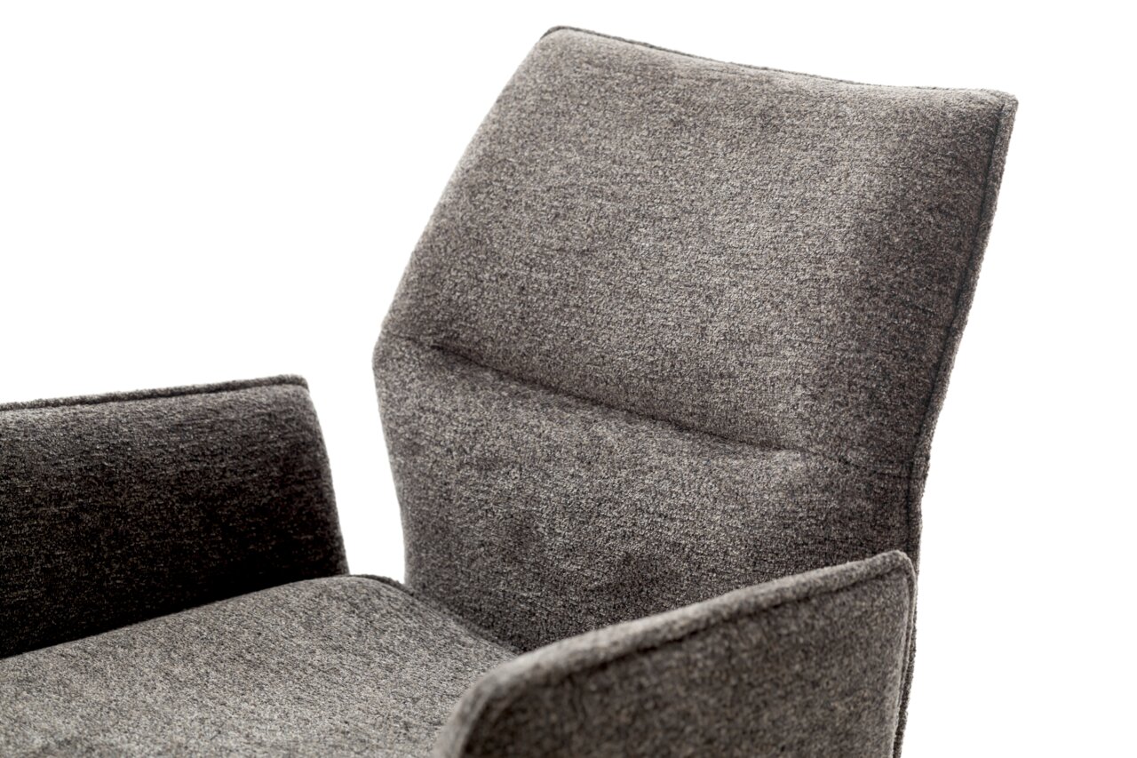 Nahaufnahme eines grauen Barstuhls mit gepolsterter Rückenlehne und Armlehnen, seitliche Perspektive