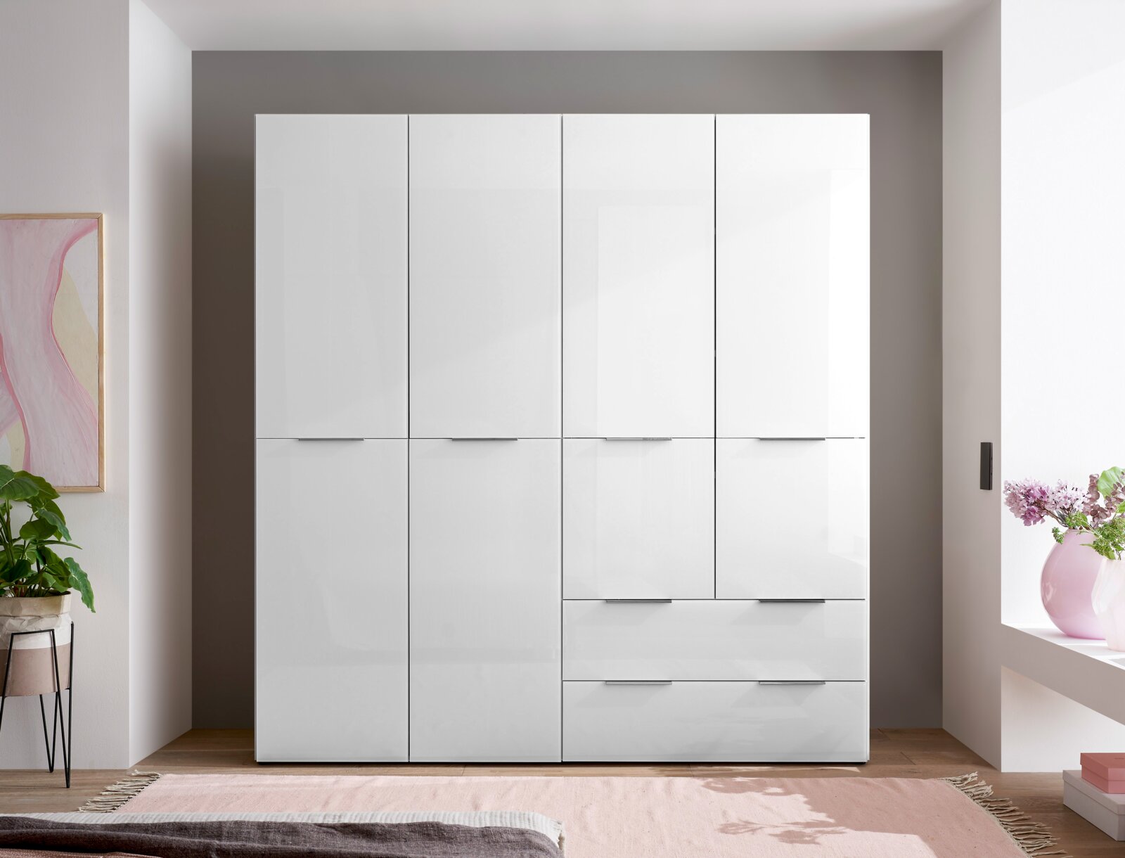 Weißer, hochglänzender Kleiderschrank mit vier Türen und zwei Schubladen, frontal aus der Vorderansicht im Schlafzimmer fotografiert