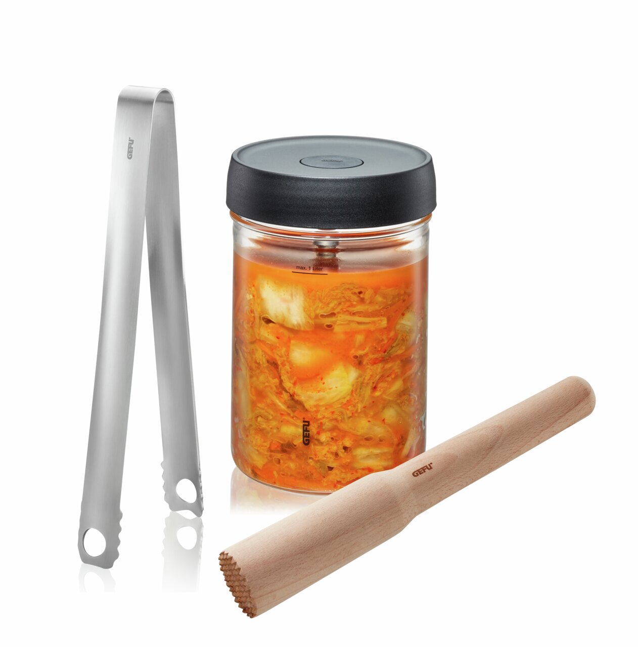 Fermentatieset Nativo, bestaande uit een glazen pot met een zwarte deksel, gevuld met gefermenteerde groenten, een roestvrijstalen tang en een houten stamper, gezien vanuit vooraanzicht.