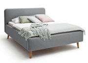 Graues Polsterbett mit Holzfüßen, dekoriert mit mehreren Kissen und einer Decke, seitliche Perspektive