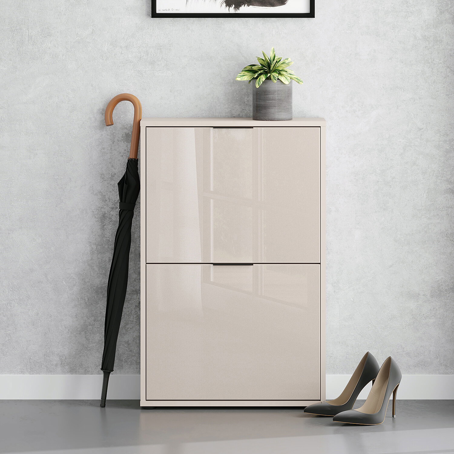 Modernes, hochglänzendes Schuhschrank-/Sideboard in Beige mit zwei Klapptüren, frontal aus Augenhöhe fotografiert; daneben ein schwarzer Regenschirm, oben ein Blumentopf, rechts ein Paar High Heels vor grauer Wand.