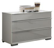 Moderne graue Nachtkonsole mit drei Schubladen, darauf Bücher, eine Brille und ein Glas Kaffee, seitliche Perspektive