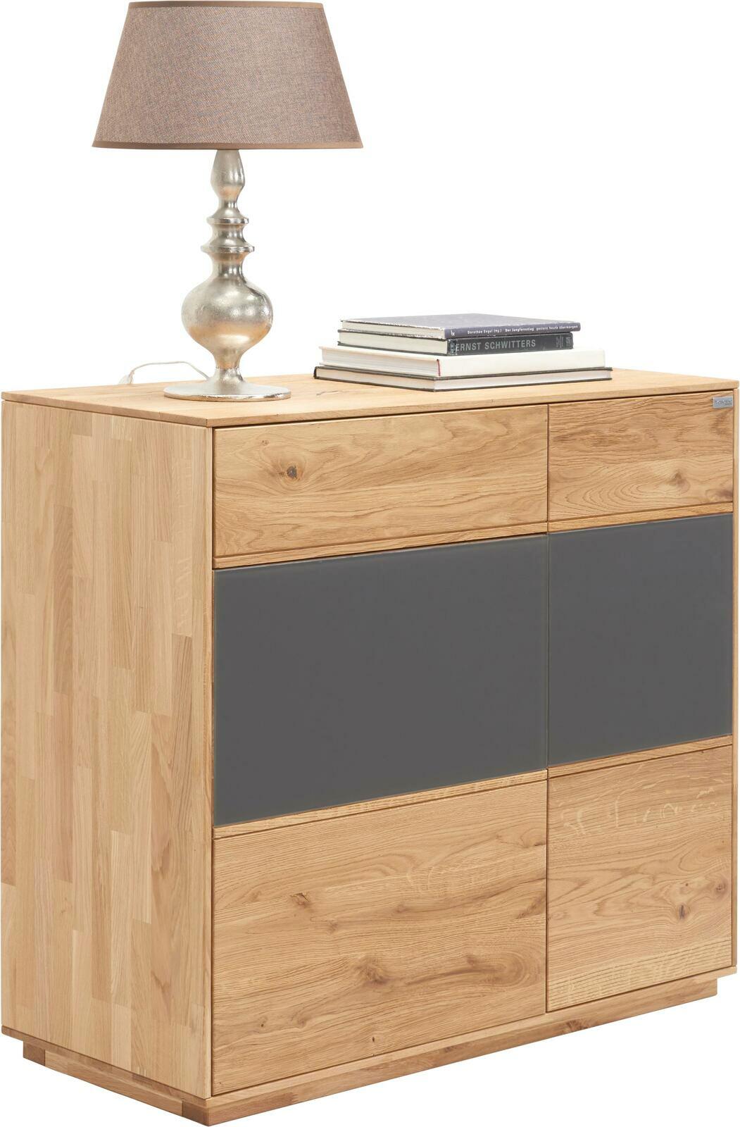 Kommode aus Holz mit zwei Schubladen und zwei Türen, darauf eine Tischlampe und Bücher, seitliche Perspektive