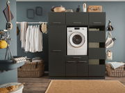 Moderne Waschküche mit dunklem Hochschrank, integriertem Waschgerät und offenen Schubladen, frontal betrachtet.