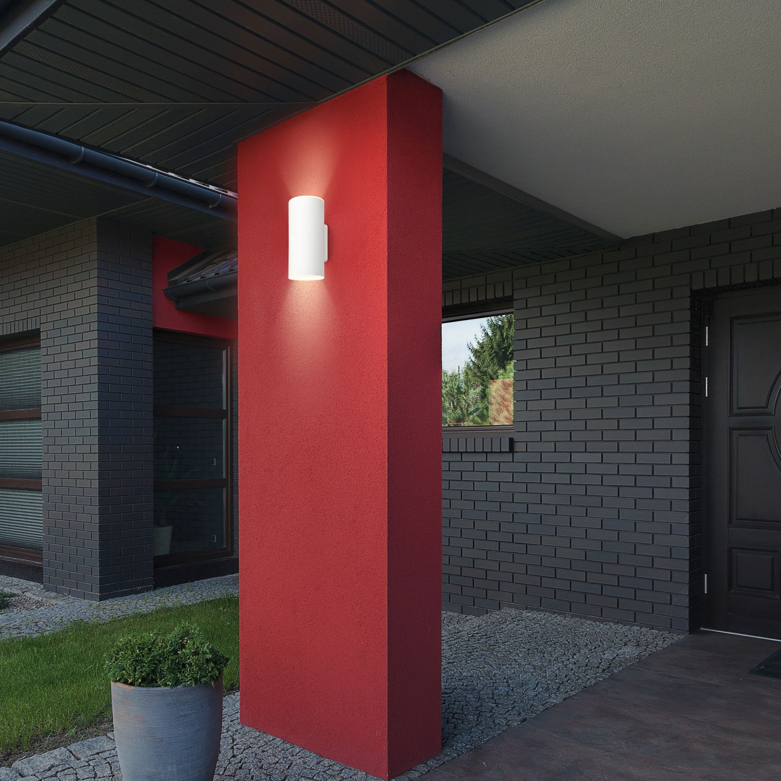 Moderne Akku-Außenwandleuchte an einer roten Wand, seitliche Perspektive