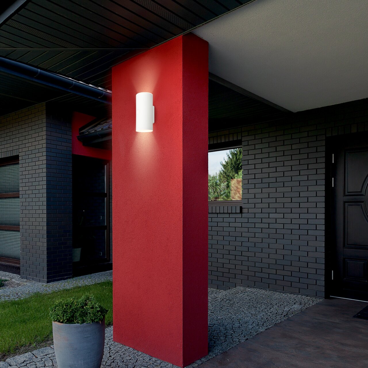 Moderne Akku-Außenwandleuchte an einer roten Wand, seitliche Perspektive