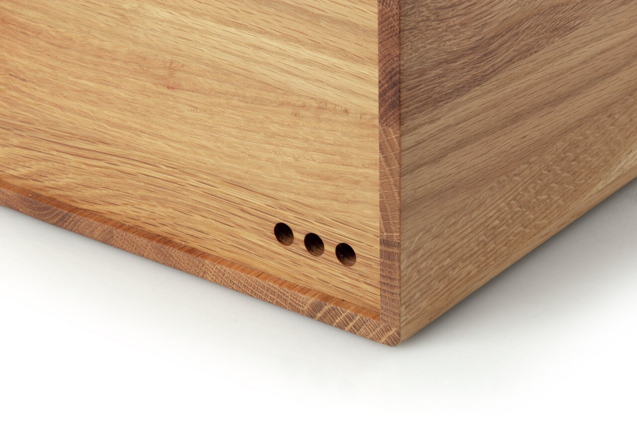 Close-up van een broodtrommel van eikenhout met drie ventilatiegaten aan de zijkant.