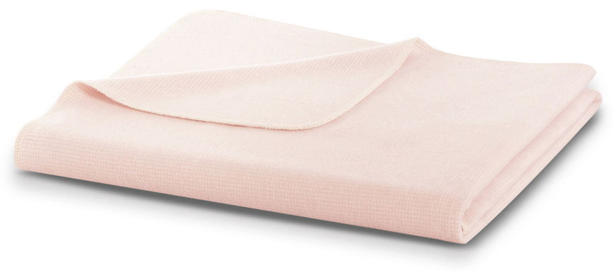 Weiche, rosa Wohndecke der Biederlack Wohndecken-Serie, gefaltet und aus seitlicher Perspektive fotografiert.
