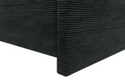 Nahaufnahme einer Ecke eines Boxspringbetts mit dunkelgrauem, geripptem Stoffbezug, perspektivisch von der Seite aufgenommen.