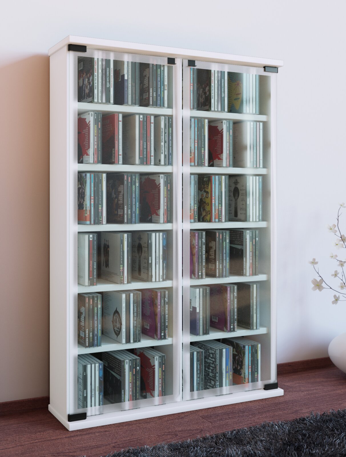 Weißer CD-/Medien-Schrank mit zwei Glas-Schiebetüren und mehreren Regalböden, gefüllt mit CDs, in leichter Schrägansicht von vorne links im Wohnraum.