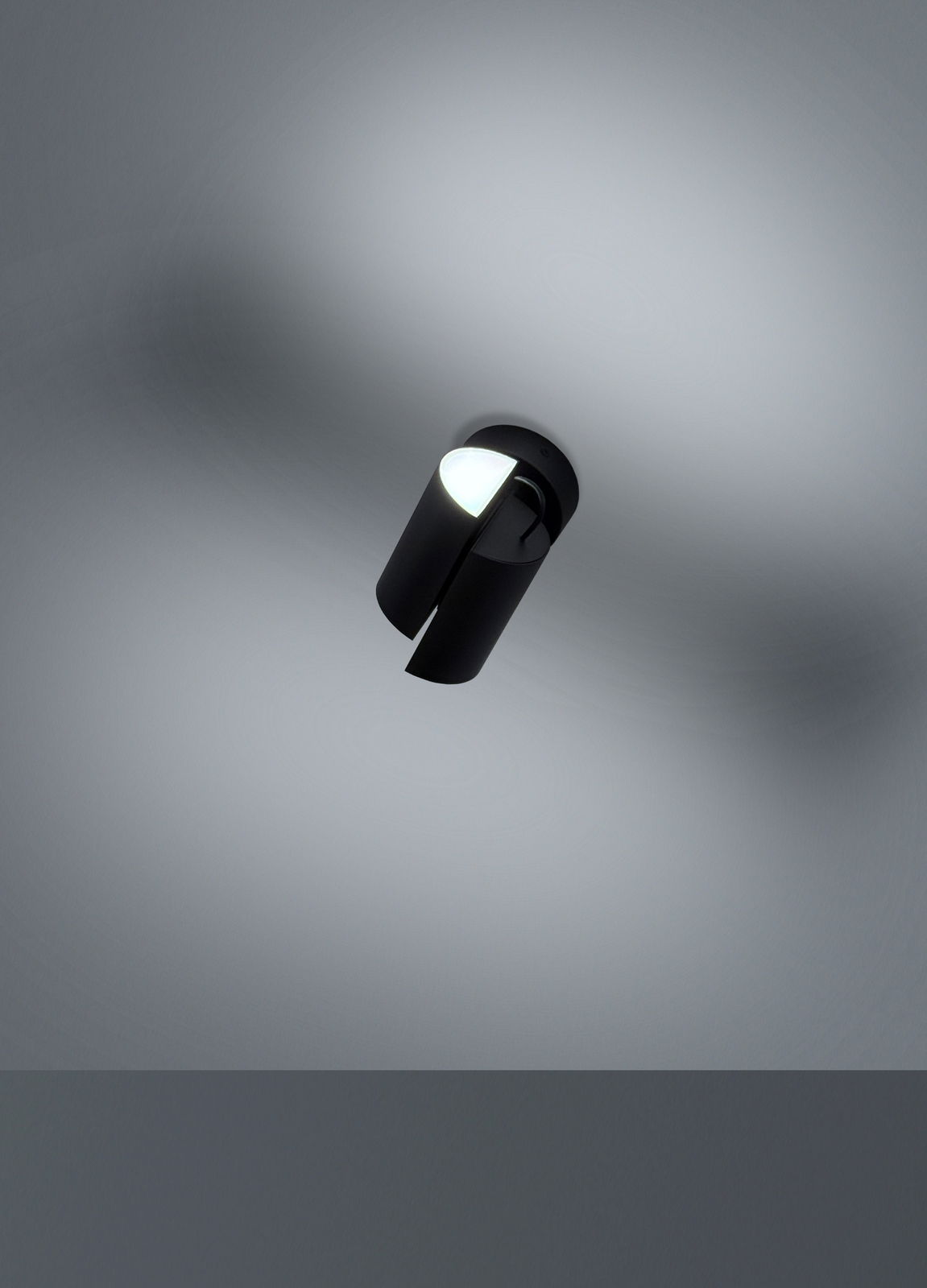 Schwarzer LED-Spot von unten betrachtet, an der Decke montiert, mit leuchtendem Lichtstrahl.