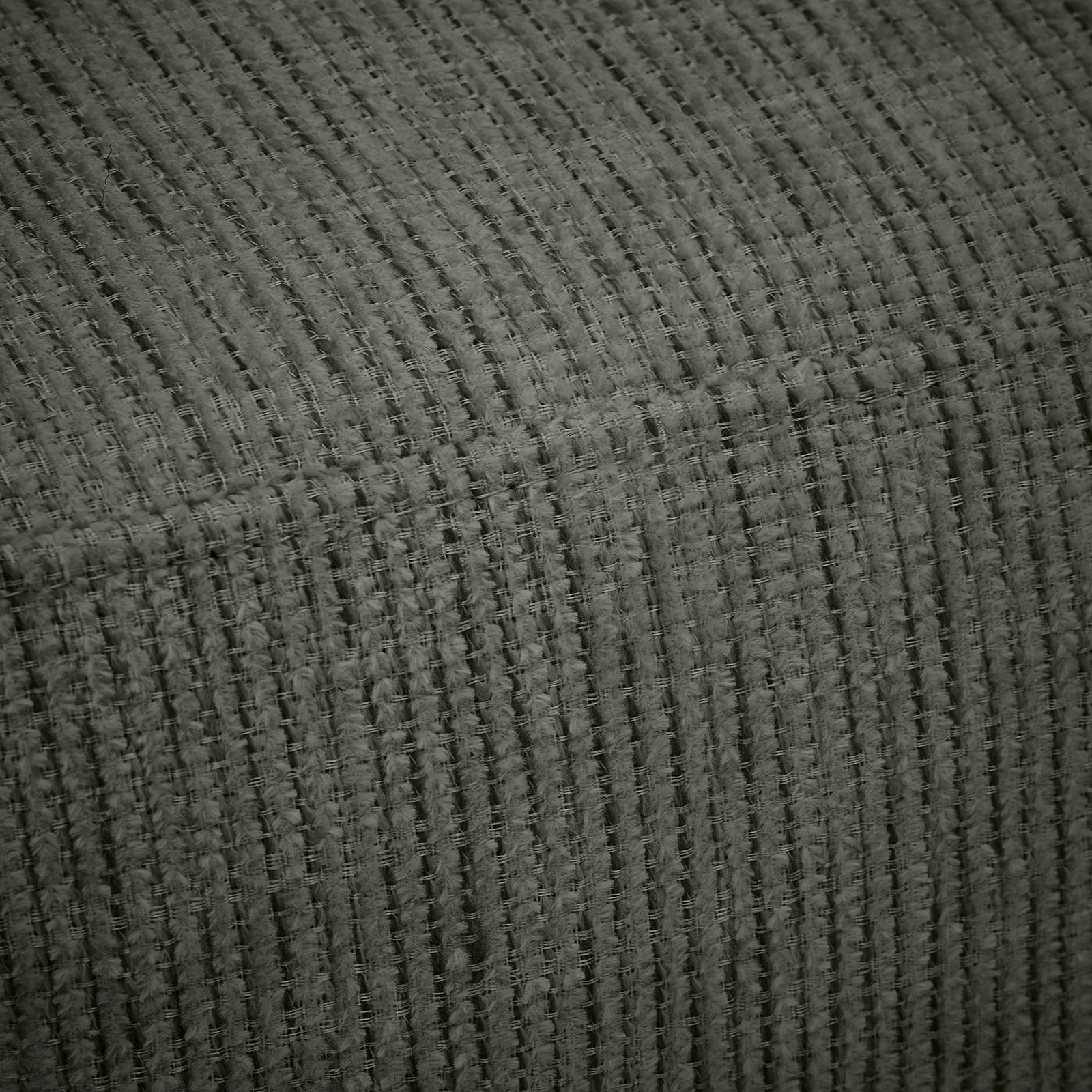 Nahaufnahme eines strukturierten, gerippten Stoffes in dunklem Grün, perspektivisch von der Seite aufgenommen.