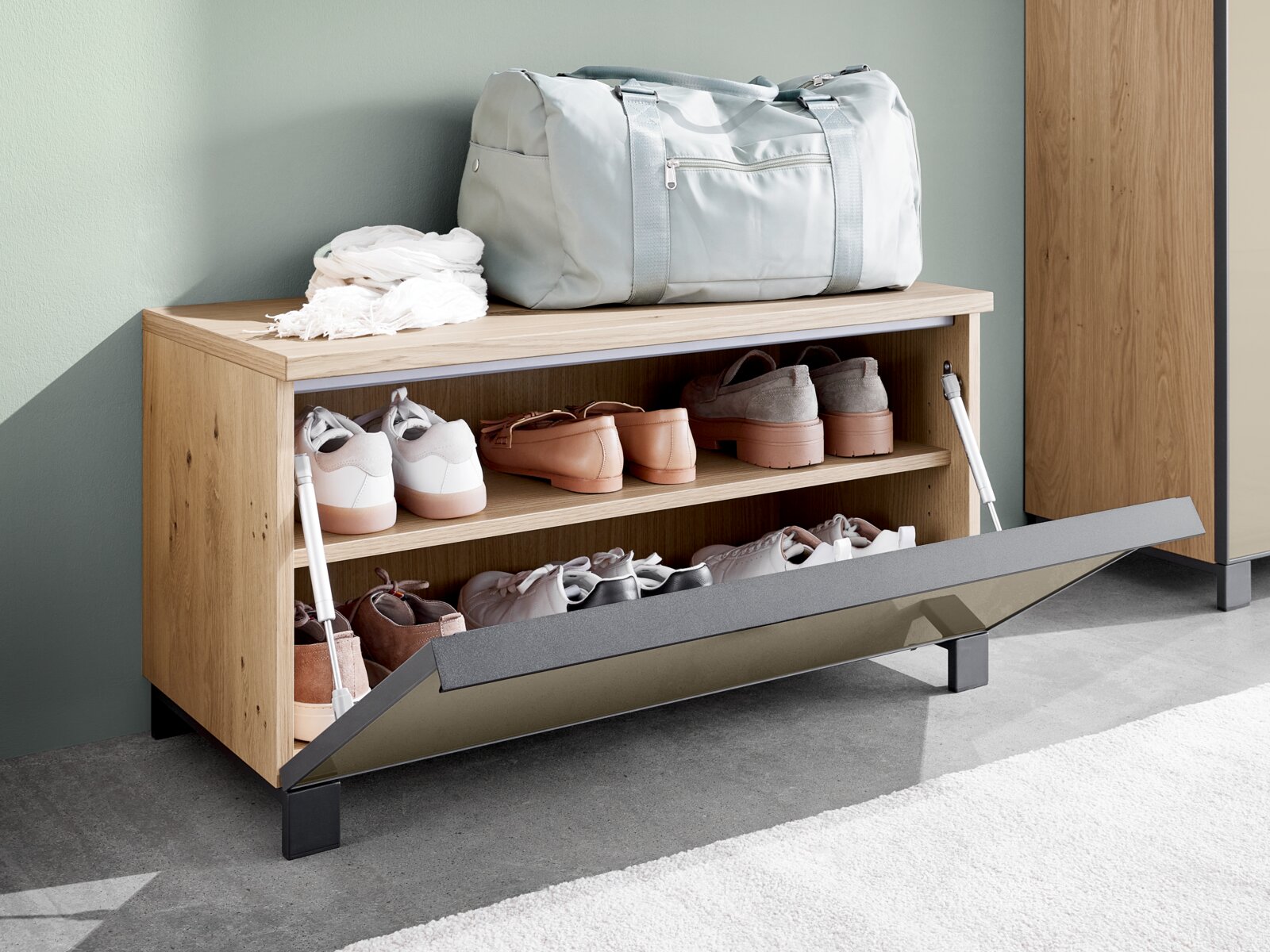 Houten kaptafel met schoenenrek, met daarop een sporttas en een sjaal, zijaanzicht