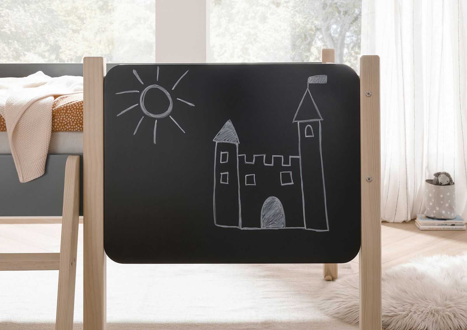 Seitenansicht eines Hausbetts mit einer Tafel, auf der eine Burg und eine Sonne gezeichnet sind.