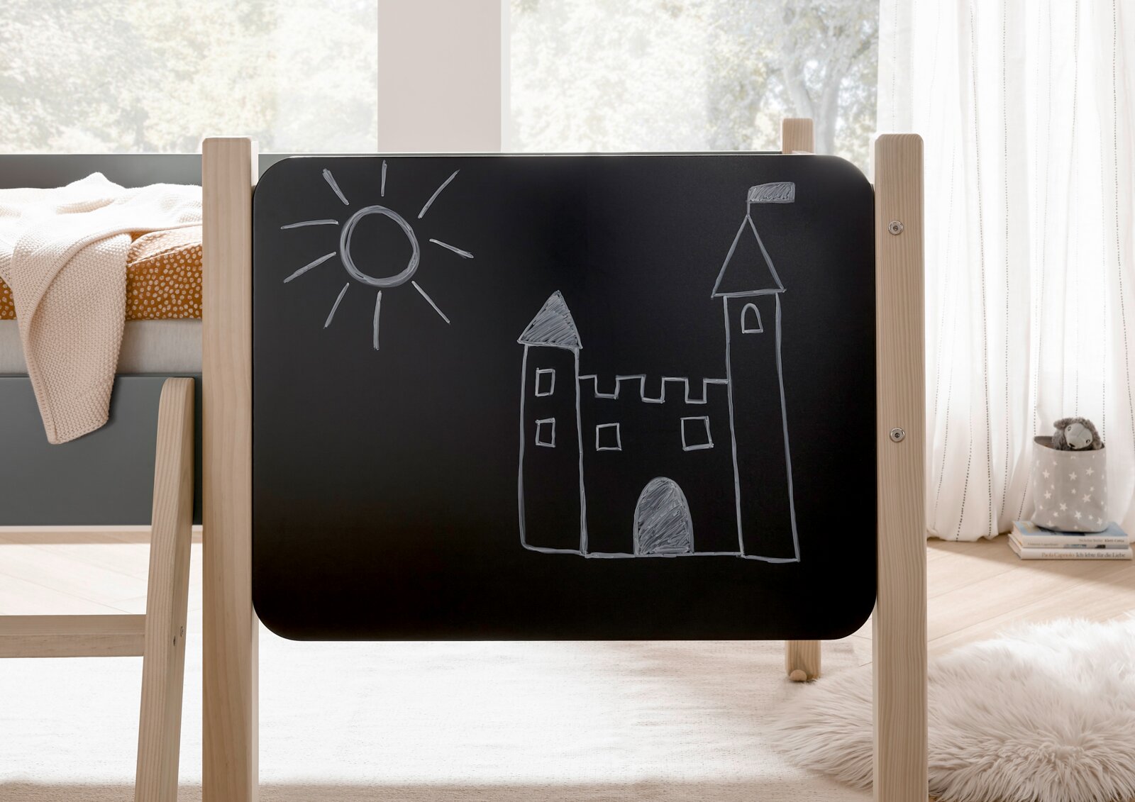 Seitenansicht eines Hausbetts mit einer Tafel, auf der eine Burg und eine Sonne gezeichnet sind.