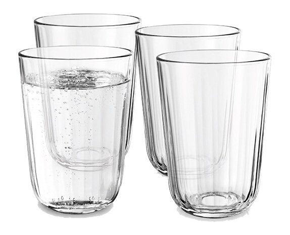 Vier klare Facettengläser, eines mit sprudelndem Wasser gefüllt, aus seitlicher Perspektive fotografiert.