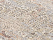 Nahaufnahme eines Designer-Teppichs mit abstraktem Muster in Beige- und Grautönen, seitliche Perspektive