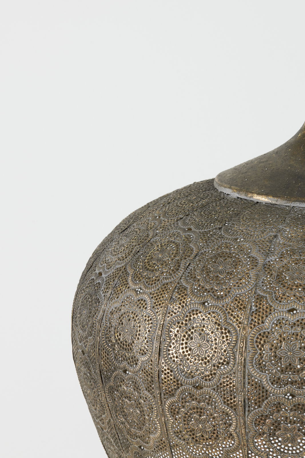 Detailansicht einer Hängeleuchte mit filigranem, orientalischem Muster in antikem Messing-Finish.