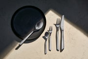Besteckset Neo 30-tlg. aus Edelstahl, bestehend aus Messer, Gabel, Löffel und Teelöffel, auf einem hellen Marmortisch von oben fotografiert.