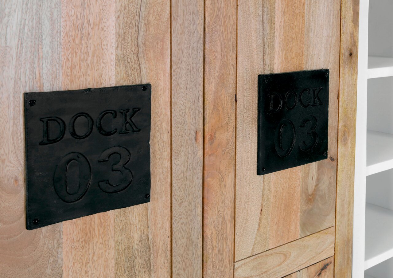 Nahaufnahme eines Highboards aus Holz mit schwarzen Metallplatten, die mit 'DOCK 03' beschriftet sind. Perspektive von vorne.