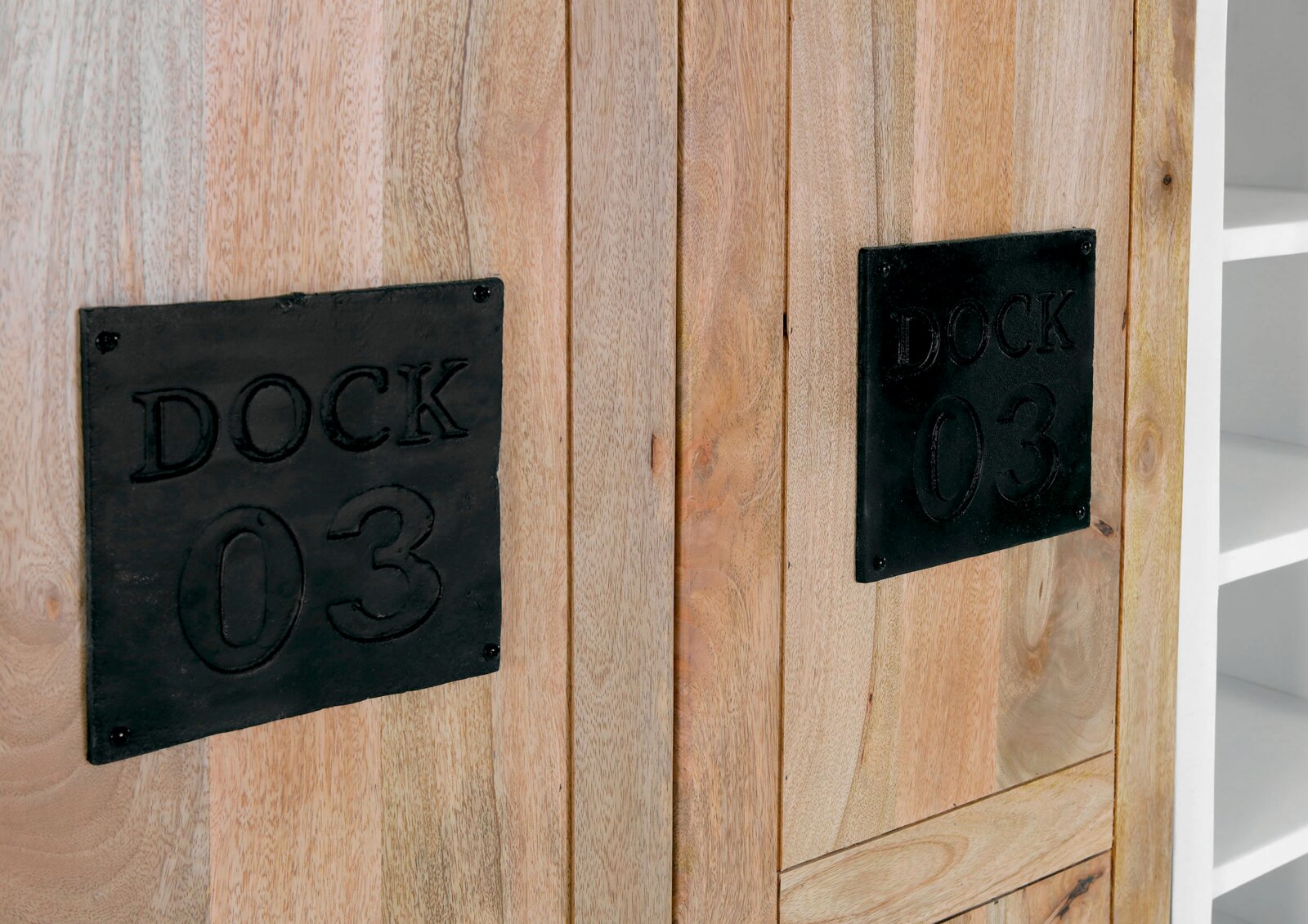 Close-up van een houten hoogkast met zwarte metalen platen waarop 'DOCK 03' staat vermeld. Vooraanzicht.