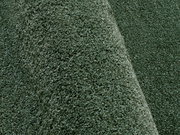 Nahaufnahme eines grünen Uni-Teppichs mit weicher Textur, seitliche Perspektive