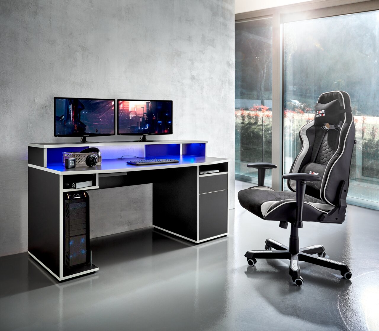 Game-Rocker Gamingstoel GAME-ROCKER Gaming Stuhl in einem modernen Raum mit Schreibtisch und zwei Monitoren, seitliche Perspektive