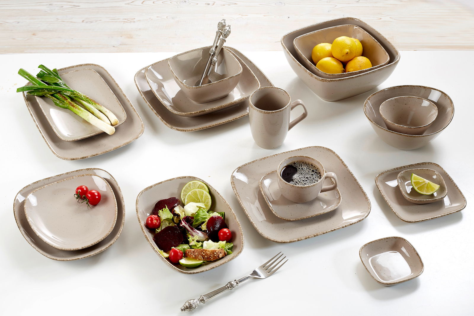 Ritzenhoff & Breker Speiseteller 27cm CASA eckig braun Verschiedene beige Geschirrteile aus der CASA Kollektion von Ritzenhoff & Breker, darunter Teller, Schalen und Tassen, auf einem Tisch von oben fotografiert.