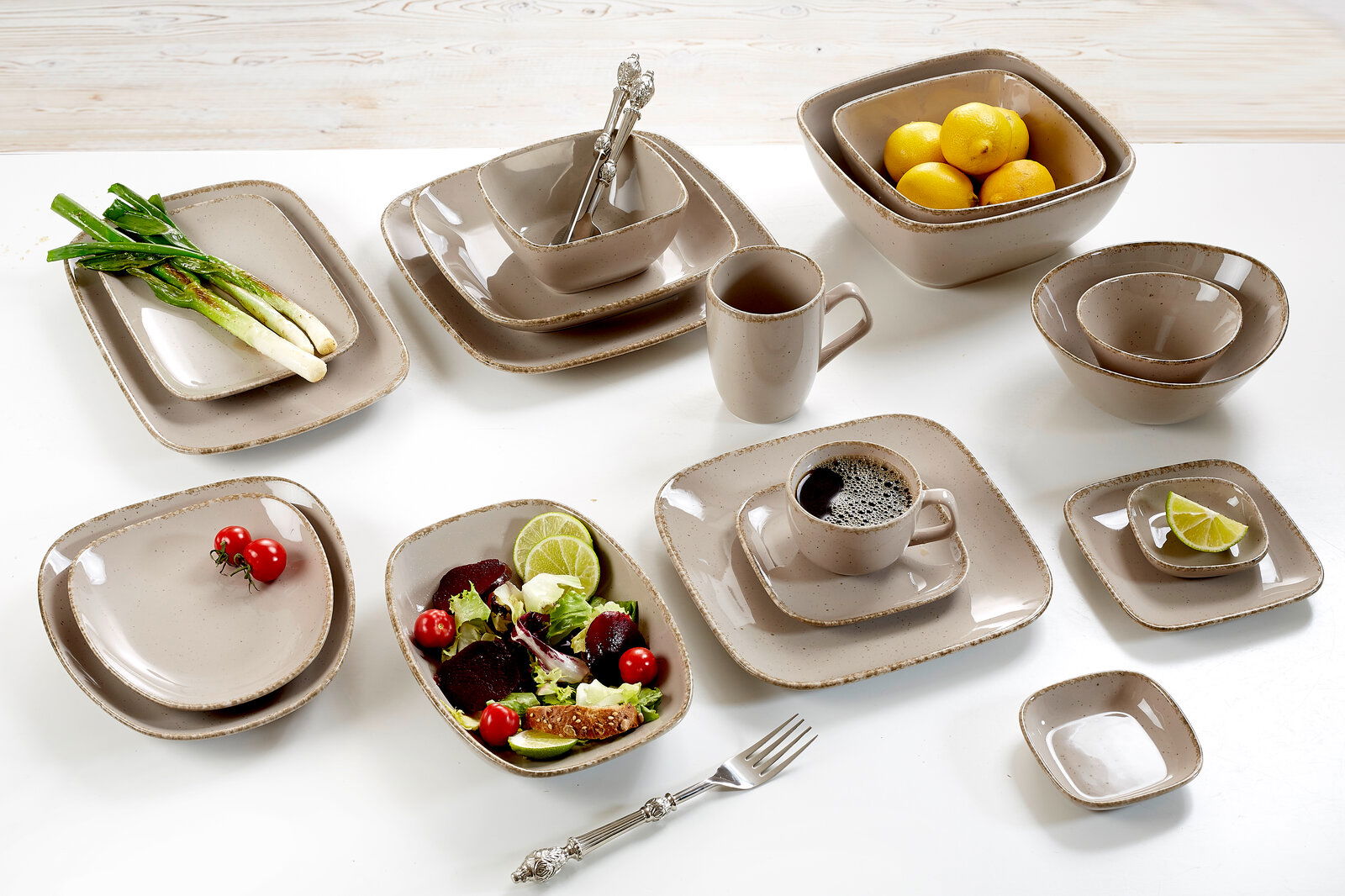 Ritzenhoff & Breker Dessertteller 22cm CASA eckig braun Verschiedene beige Geschirrteile aus der CASA Kollektion von Ritzenhoff & Breker, darunter Teller, Schalen und Tassen, auf einem Tisch von oben fotografiert.