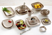 Verschiedene beige Geschirrteile aus der CASA Kollektion von Ritzenhoff & Breker, darunter Teller, Schalen und Tassen, auf einem Tisch von oben fotografiert.