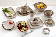 Verschiedene beige Geschirrteile aus der CASA Kollektion von Ritzenhoff & Breker, darunter Teller, Schalen und Tassen, auf einem Tisch von oben fotografiert.