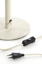 Nahaufnahme eines Lampenfußes mit rundem Sockel, Kabel und Schalter, seitliche Perspektive.