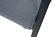 Close-up van een Comfort Plus stapelstoel met grijze stoffen bekleding en een zwart frame, gezien vanaf de zijkant