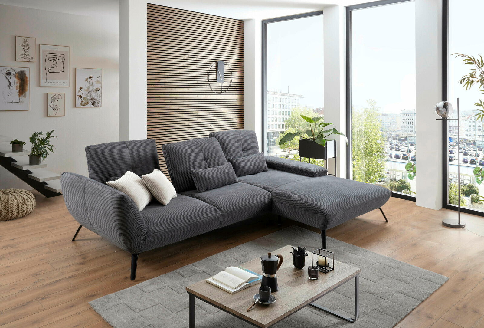 StepOne Ecksofa NEWPORT Graue Rundecke in modernem Wohnzimmer mit großen Fenstern, von vorne betrachtet.