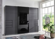 Moderner, dreitüriger Schwebetürenschrank in dunklem Design, frontal abgebildet in einem hellen Raum mit großen Fenstern.