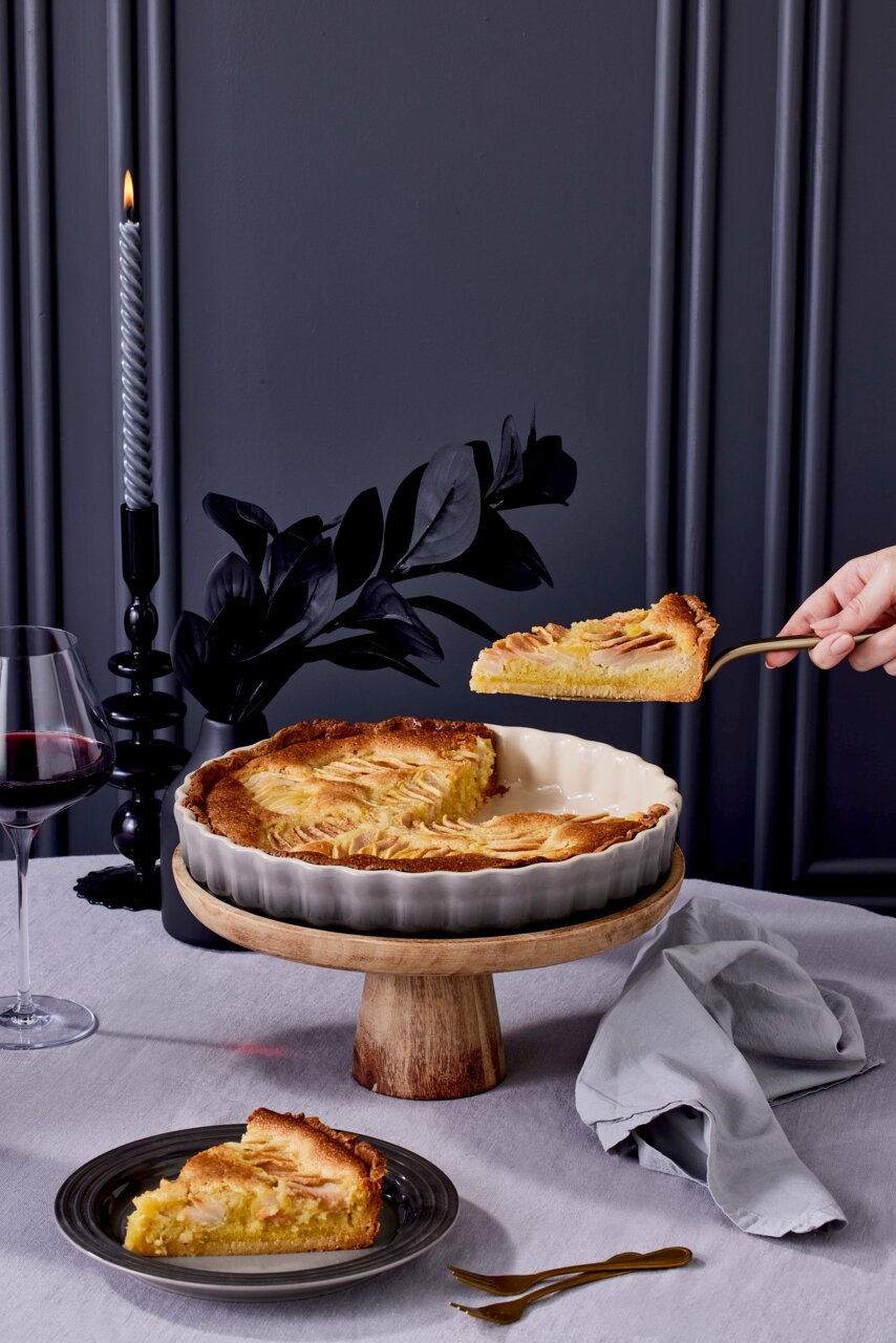 Tarte-Form 28cm Flint mit gebackener Tarte, auf einem Holzständer präsentiert, seitliche Perspektive.